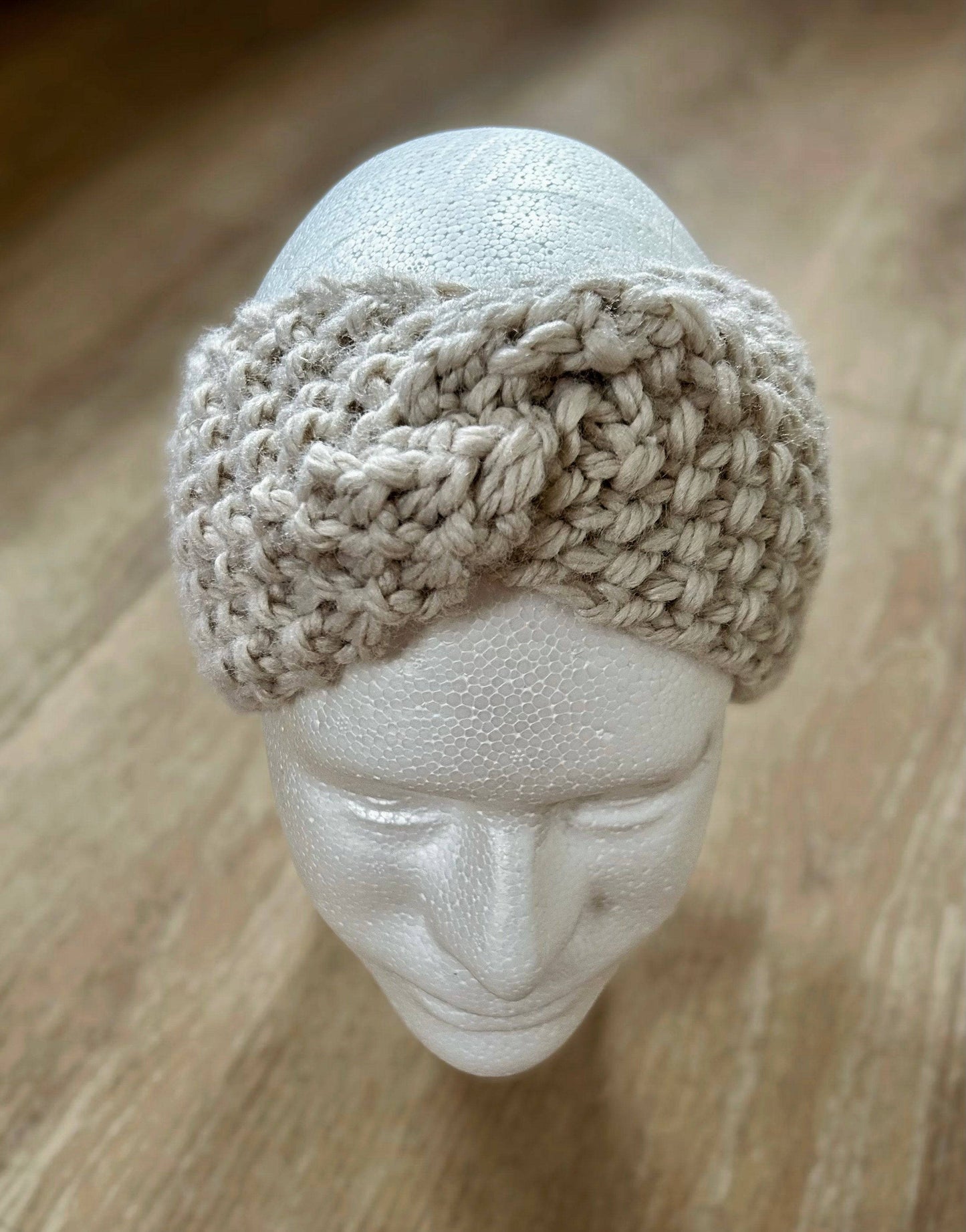 Foam mannequin head with a gray crocheted headband featuring a central twist.